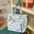 Floral print convertible tote backpack with plush bear charm, light blue straps and pockets. - Shoulder Bag / With Pendant / Blue