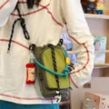 Vista dettagliata della borsa a tracolla tattica verde con corda decorativa e ciondolo. - Con Ciondolo / Verde