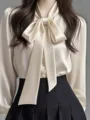 Elegantes Satinblusen-Detail mit schickem Schleifenkragen und glattem Fall für Damen. - S / Oberteile / Gebrochenes Weiß