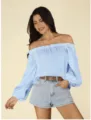 Details des hellblauen schulterfreien Langarmshirts mit Rüschenausschnitt und Jeansshorts. - S / Himmelblau