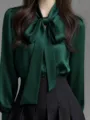 Detail view of elegant dark green satin blouse with bow tie collar and long sleeves. - Dark Green