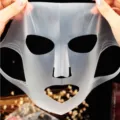 Reusable silicone face mask cover detail shot, translucent elastic skin care tool for hydration. - White