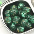 Vue détaillée de perles en résine nacrée vert foncé de 16mm avec feuille d'or pour loisirs créatifs. - 16mm (Trou d'environ 2,5mm) / Vert Foncé
