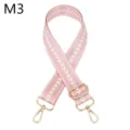 Nahaufnahme des verstellbaren rosa Taschengurt mit Zickzack-Muster und goldener Hardware. - m3