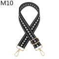 Nahaufnahme des schwarz-weißen gemusterten Taschenriemens mit goldener Metallhardware. - m10