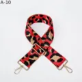 Primer plano de la correa de bolso con estampado de leopardo rojo y hebillas doradas. - Dorado / Rojo