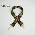 Vue rapprochée de la bandoulière de sac noire avec motif tournesol et accessoires en métal doré. - Motif Tournesol