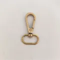 Vue de detail rapprochee d'un mousqueton pivotant en metal doore pour sacs et cles. - Or Doré Carte (6-Fen)