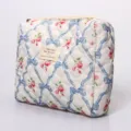 Quilted floral cosmetic bag with blue ribbon design, padded portable makeup pouch for daily use. - Bow Blue Floral Cosmetic Bag