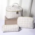 Detailed view of the white tweed cosmetic bag set, featuring elegant gold thread texture and durable zippers. - Medium / White