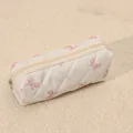 Quilted cosmetic bag detail view showing soft pink bow print and smooth zipper closure. - Small Pink and White Bow Quilted Cosmetic Bag