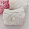 Detailed shot of white cosmetic bag with delicate floral pattern and cute bow for travel. - White Lace Cosmetic Storage Bag