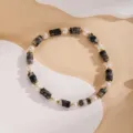 Primo piano dettaglio del bracciale di perle vintage con cilindri in pietra nera. - 19#