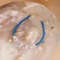 Gros plan d'un bracelet de perles bleues sur fond de coquillage naturel, style élégant. - 6#