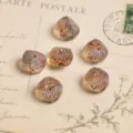 Gros plan de perles en verre tchèque vintage facettées à motif chevrons et reflets irisés. - Or champagne
