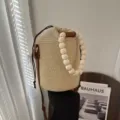 Woven straw bucket bag with wooden bead handle and leather strap for women summer beach. - Off White