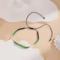 Close-up of minimalist green, white and black beaded woven bracelet with adjustable cord. - Style 6