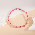 Close-up detail of handmade pink heart beaded bracelet with gold metallic spacer beads. - Rose Red