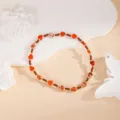 Handmade heart beaded bracelet detail, featuring red stone beads and metallic spacer accents. - Orange Red