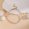 Close-up detail view of elegant white and red beaded bracelet with adjustable gold chain. - Pearl Red