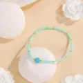 Détail de bracelet de perles turquoise avec intercalaires dorés sur accessoire artistique. - Motif #1