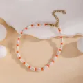 Vue de détail d'un bracelet de perles superposé élégant avec des perles blanches et oranges. - Orange Perle