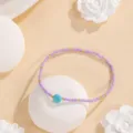 Détail de bracelet de perles violettes avec pierre turquoise et intercalaires or. Bijou boho. - Pois (#4)
