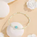 Close-up detail of minimal seed bead bracelet with turquoise stone and delicate gold spacers. - Geometric #5