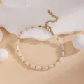 Vue détaillée de l'élégant bracelet de perles blanches et dorées avec chaîne réglable. - Or Perle