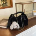 Borsa a mano in peluche nera con ciondolo coniglio, manico in pelle e catena dorata chic. - Nero