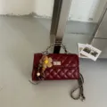 Bequeme burgunderrote gesteppte Leder-Ketten-Umhängetasche mit Drehverschluss und Blüte. - Ohne Anhänger / Rot
