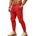 Close-up of red men's cuffed sweatpants featuring an elastic drawstring waistband and pockets. - S / Bottoms / Bright Red