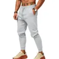 Close-up of men's gray casual sweatpants featuring elastic drawstring waist and cuffed hems. - Light Gray