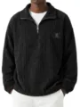 Detailed view of men's black corduroy stand collar zip sweatshirt with textured chest patch. - S / Tops / Black