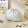 Blue and white striped quilted makeup pouch with cute drawstring design for travel storage. - Drawstring Bag / Striped Blue