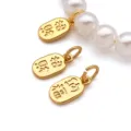 Close-up detail of gold plated metal charms and white pearl beads for DIY jewelry making. - Fortune Character Tag Pendant (T3724) / 17x7x1.5mm (1 Piece) / Gold