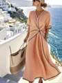 Detail lifestyle shot of resort V-neck twist dress featuring stylish contrast piping by the blue sea. - S / Dresses / Orange