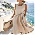 Detail shot of women's sleeveless maxi dress with contrast piping and scenic seaside view background. - S / Dresses / Beige Sleeveless