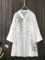 Detailed view of the white embroidered blouse, wooden background hanging style. - Color 10