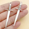Close-up of antique silver sword pendants charms for DIY jewelry making necklaces bracelets. - 1 Piece/Pack (58x18mm)