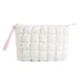 Witte gewatteerde cosmetische etui detail, pluizige cloud make-uptas met roze polsbandjecloseup. - Wit