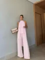 Detailed shot of the pink asymmetric sleeveless top and elegant wide-leg trousers outfit. - Pink