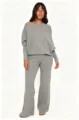 Detalle del conjunto de punto suave con suéter de hombro caído y pantalón elegante en gris. - S / Gris