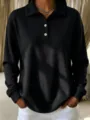 Top polo negro de tejido gofrado de manga larga con cierre de botones y cuello clásico. - S / Negro