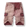 Detail view of men's vintage washed red cargo shorts featuring multi-pockets and button fly. - 30 / Bottoms / Red