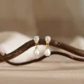 Elegante oorbellen met sprankelende zirkoon en glanzende parels op tak gepresenteerd. - Stijl 5 / Goud