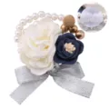 Exquisite wedding wrist corsage featuring artificial flowers, pearls, and a silver bow detail. - Wrist Corsage / Milk White