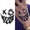 Scary graffiti smile tattoo sticker featuring a creepy grinning face design for hand. - Creepy Smile (HA069) / 8x8cm