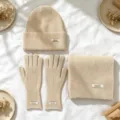 Detailansicht eines dreiteiligen Wintersets aus beige Strickmütze, Handschuhen und Schal. - 3-Teiliges Set (Mütze+Schal+Handschuhe) / Gebrochenes Weiß