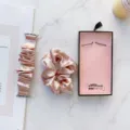 Detailansicht des rosa Samt Scrunchie Uhrenarmbands und passenden Haargummis im Set auf Marmor. - Solid Rose Gold
